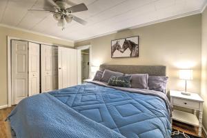 - une chambre avec un lit bleu et un ventilateur de plafond dans l'établissement Charming Harkers Island Home - Fish and Boat!, à Harkers Island