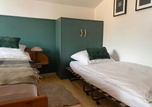 a bedroom with two beds and a green wall at Ferienwohnung Kaiserin in Reit im Winkl
