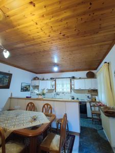 cocina con techos de madera, mesa y sillas en Lagadia Apartments, en Lagadia