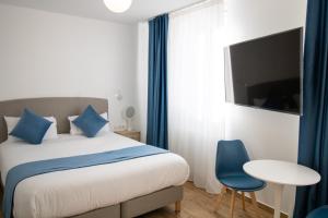 1 dormitorio con cama, mesa y TV en Les Rebelles en París