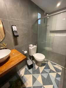 La salle de bains est pourvue de toilettes, d'un lavabo et d'une douche. dans l'établissement Pousada do Paiva, à Flecheiras
