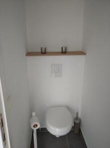 a bathroom with a toilet with two cups on a shelf at Terrasses de Malmedy Lodge 417 in Malmedy +24 photos