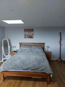 a bedroom with a large bed in a white room at Sea View Studio in Castlerock