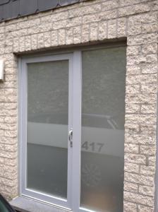 una porta di vetro in un edificio di mattoni con il numero sopra di Terrasses de Malmedy Lodge 417 a Malmedy