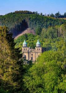 a building in the middle of a hill with trees at Terrasses de Malmedy Lodge 417 in Malmedy
