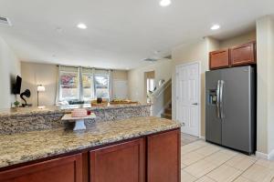 a kitchen with a refrigerator and a counter top at High End Midtown Home With Fireplace And Ensuite Baths in Reno