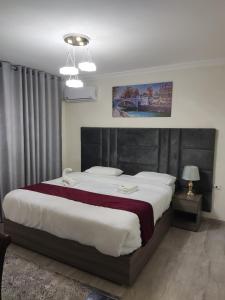 Amman La Maison Hotel Suites في عمّان: غرفة نوم بسرير كبير في غرفة