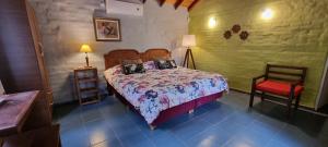 1 dormitorio con 1 cama y 1 silla en Hostal La Quebrada en Cortaderas