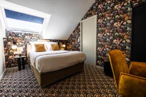 - une chambre avec un grand lit et du papier peint floral dans l'établissement Hôtel Paulette Rouen Centre Cathédrale, à Rouen