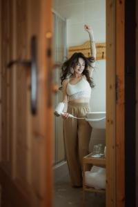 Eine Frau, die vor einem Badezimmerspiegel steht. in der Unterkunft Bajka Hotel & Resort in Grodziec
