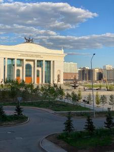 een gebouw met een standbeeld erop bij Апартаменты Миллениум 2 in Astana