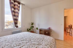 a bedroom with a bed and a large window at Appartement pour 4 personnes à Bagneux in Bagneux