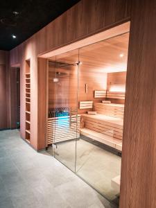 菲伯布伦All-Suite Resort Fieberbrunn inklusive Gästekarte & Lauchsee-Eintritt的木墙客房中的步入式淋浴间