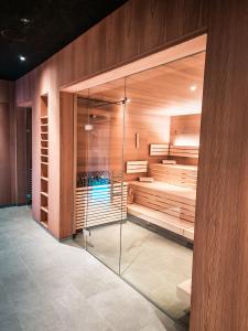 a walk in shower in a room with wooden walls at All-Suite Resort Fieberbrunn in Fieberbrunn