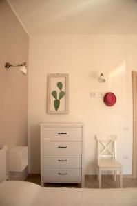 a bedroom with a bed and a dresser and a chair at Turtle House in Palau