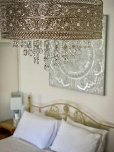 una lámpara de araña colgada sobre una cama en un dormitorio en The Crown & Victoria Inn, en Tintinhull