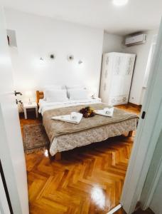 a bedroom with two beds and a wooden floor at Palace Luxury Apartments The Heart of Belgrade in Belgrade