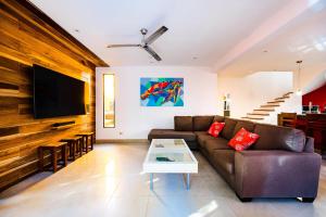 sala de estar con sofá y TV en A Tamarindo Sunset, en Tamarindo