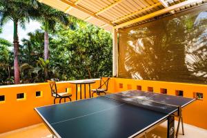 una mesa de ping pong en un balcón con palmeras en A Tamarindo Sunset, en Tamarindo
