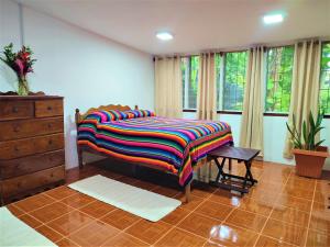 a bedroom with a bed with a colorful blanket on it at Maya Mountain Lodge in San Ignacio