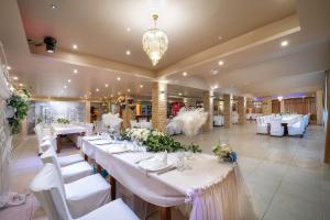 a large banquet hall with white tables and white chairs at Hotel Rivera in Dobrich