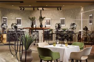 a restaurant with a white table and green chairs at Riva Del Sole Resort & SPA in Castiglione della Pescaia