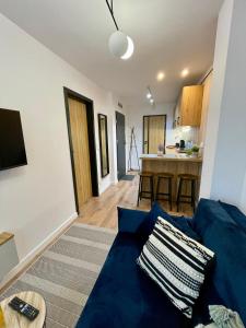 a living room with a blue couch and a kitchen at Apartament w sercu miasta in Radom +9 photos