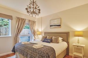 a bedroom with a bed and a chandelier at Ty Gwawr in Oxwich