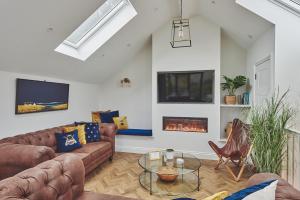 a living room with leather couches and a fireplace at Ty Alice in Oxwich