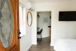 a room with a door and a bed and a television at Cozy Studio - Blocks from the Ocean! in Jacksonville Beach