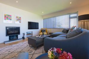 a living room with two couches and a tv at Secret Beach in Carbis Bay