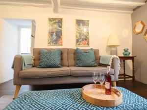 a living room with a couch and a table with wine glasses at 3 Ivy Court in Dolgellau