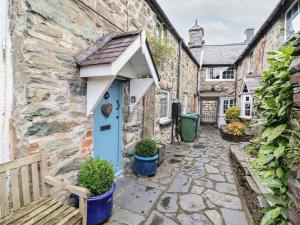 a stone house with a blue door and an awning at 3 Ivy Court in Dolgellau