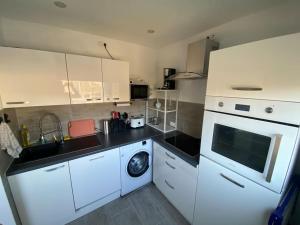 a kitchen with white cabinets and a washing machine at Ferienwohnung 3,5 Zimmer zentrale Lage in Duisburg +8 photos