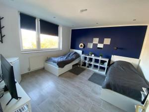 a bedroom with a blue wall and a couch and a television at Ferienwohnung 3,5 Zimmer zentrale Lage in Duisburg