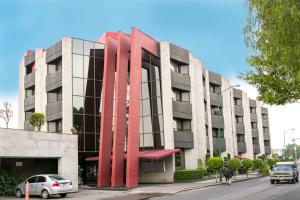 un edificio con esculturas de metal rojo en su lateral en Hotel Abastos Plaza, en Ciudad de México