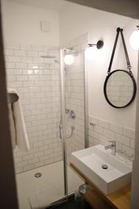 a white bathroom with a shower and a sink at Wirtshaus Im Schloss Fürsteneck in Fürsteneck