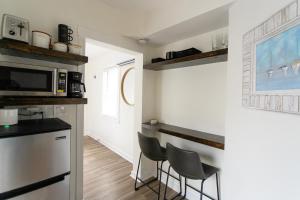 a kitchen with two chairs and a counter with a microwave at Cozy Studio - Blocks from the Ocean! in Jacksonville Beach
