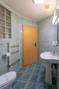łazienka z umywalką, toaletą i drzwiami w obiekcie Pensiunea Joker w Sighișoarze