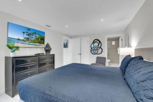 um quarto com uma cama azul e uma televisão de ecrã plano em Easy living, down by the sea! Close to the beach & pool in beautiful beachfront resort em South Padre Island