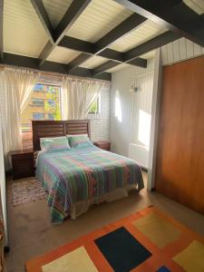 a bedroom with a bed with a colorful comforter at Cabañas Patagonia LicanRay in Licán Ray