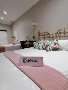 1 dormitorio con 2 camas y manta rosa y blanca en Mi Vida Guesthouse, en Klerksdorp