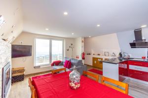una cocina y una sala de estar con una mesa con un jarrón. en Bungalow QJ, en Covilhã
