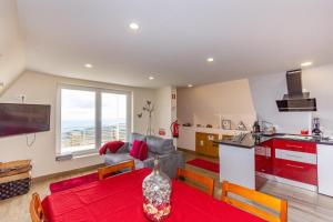科維良的住宿－Bungalow QJ，厨房以及带红色桌椅的起居室。