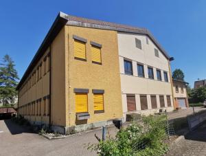 un bâtiment avec volets jaunes sur son côté dans l'établissement Anstatthotel Affoltern am Albis - self-check-in, à Affoltern
