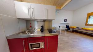 a kitchen with a sink and a microwave at Anstatthotel Affoltern am Albis - self-check-in in Affoltern