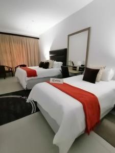 a hotel room with two beds and a mirror at Mi Vida Guesthouse in Klerksdorp