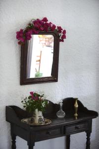 a mirror on a wall above a table with flowers at Vagia Traditional, Aegina Island in Vaia