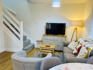 a living room with a couch and a tv at Cloud9StayZ at The Oakridge in Woking