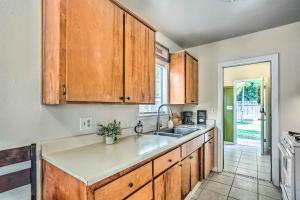 a kitchen with wooden cabinets and a sink at Kingsburg Home with Patio about 22 Mi to Fresno! in Kingsburg